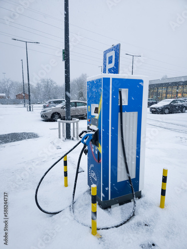 Atak zimy i ładowanie samochodu elektrycznego photo