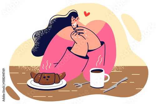 Woman sits at table with hot coffee and croissant, enjoys going to coffee shop with breakfasts