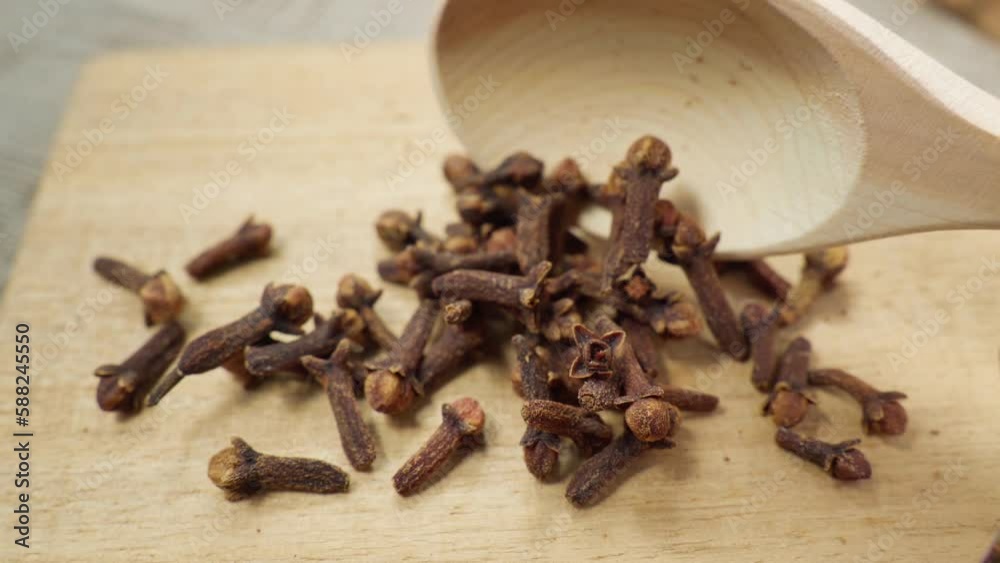 Dry spice cloves in wooden background. Macro, food. A spoon with carnation seeds. Dry spice cloves in wooden background. Macro, food. A spoon with carnation seeds.