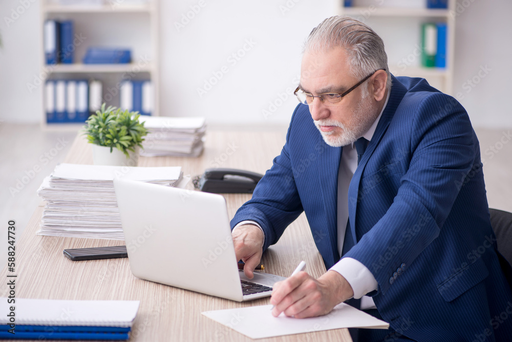 Old male employee working in the office Old male employee working in the office