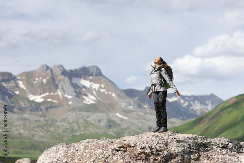 Hiker breathing fresh air on the top of a mountain