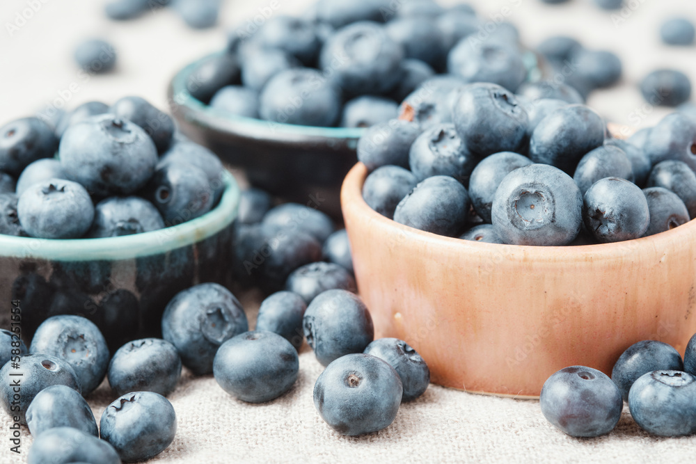Three ceramic bowls with blueberries and berries scattered around. Three ceramic bowls with blueberries and berries scattered around.