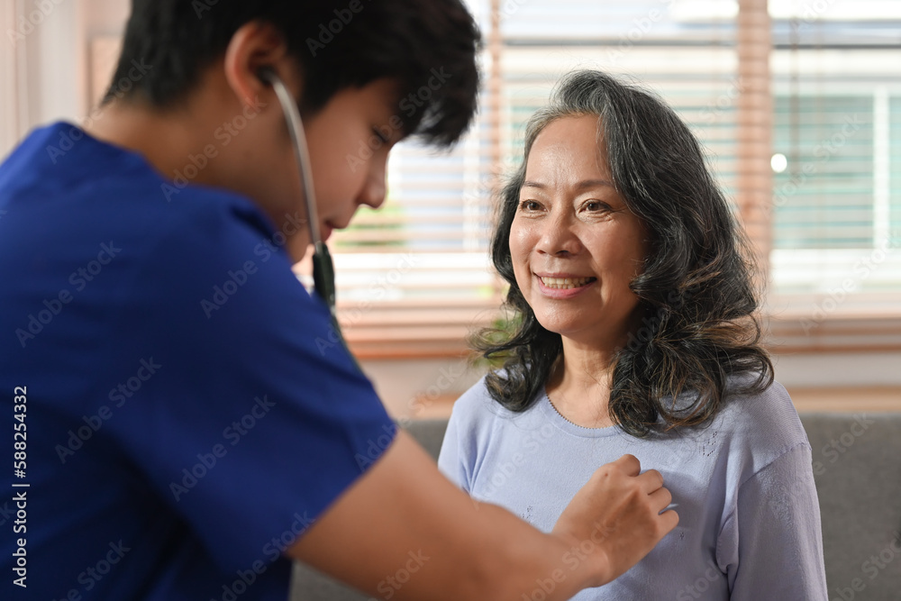 Doctor holding stethoscope checking heart and lungs of senior woman during home care visit. Elderly healthcare concept Doctor holding stethoscope checking heart and lungs of senior woman during home care visit. Elderly healthcare concept