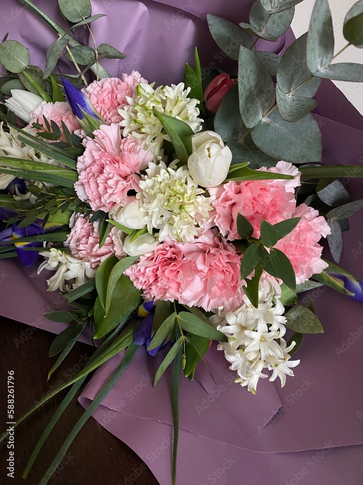 A beautiful bouquet of pink and white tulips, hyacinths, irises and fluffy carnations with green eucalyptus