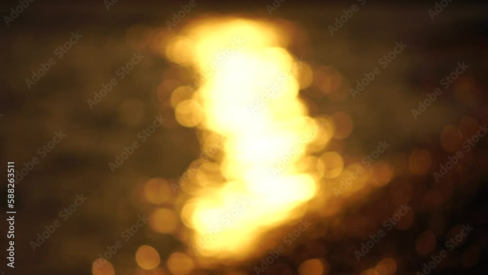 Blurred golden sea at sunset. The sun reflects and sparkles on the waves with bokeh, illuminating the golden sea. Holiday recreation concept. Abstract nautical summer ocean sunset nature background. Blurred golden sea at sunset. The sun reflects and sparkles on the waves with bokeh, illuminating the golden sea. Holiday recreation concept. Abstract nautical summer ocean sunset nature background.
