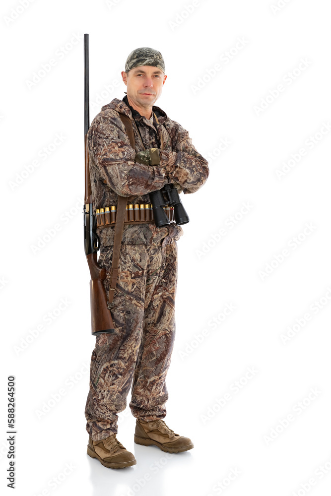 Full length portrait of duck hunter with a rifle on his shoulder and binoculars with folding arms isolated on white background. Fifty-year-old man in hunting uniform with a shotgun posing in studio Full length portrait of duck hunter with a rifle on his shoulder and binoculars with folding arms isolated on white background. Fifty-year-old man in hunting uniform with a shotgun posing in studio