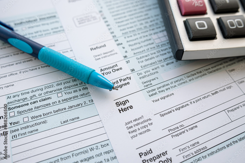 1040 tax form with pen and calculator on office desk