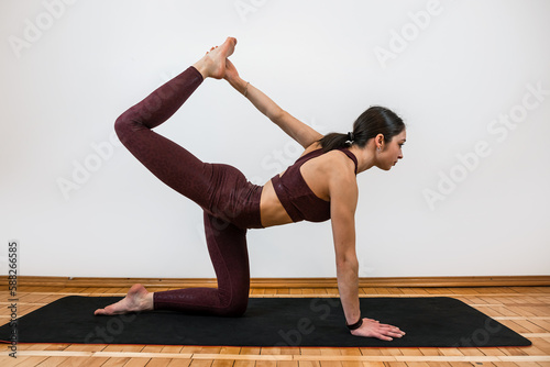  Athletic woman in sportswear doing yoga fitness exercises on mat at home