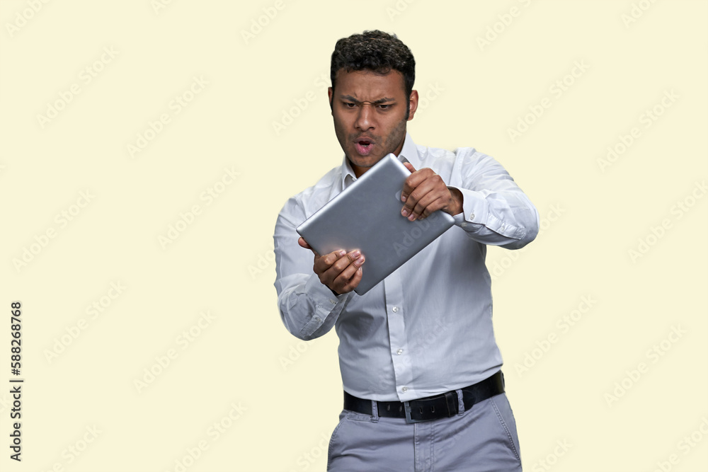 Portrait of a young indian man playing game with tablet. Isolated on white background. Portrait of a young indian man playing game with tablet. Isolated on white background.