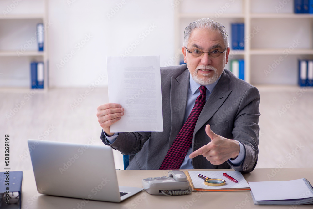 Old male employee working in the office