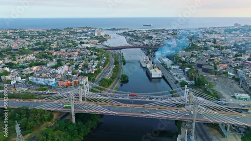 Traffic passes famous bridges over river Ozama in Santo Domingo, aerial sunrise photo