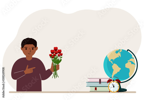 The boy holds in his hand a bouquet of flowers next to textbooks, a globe and an alarm clock. The concept of September 1, the day of knowledge, soon to school, the beginning of studies.