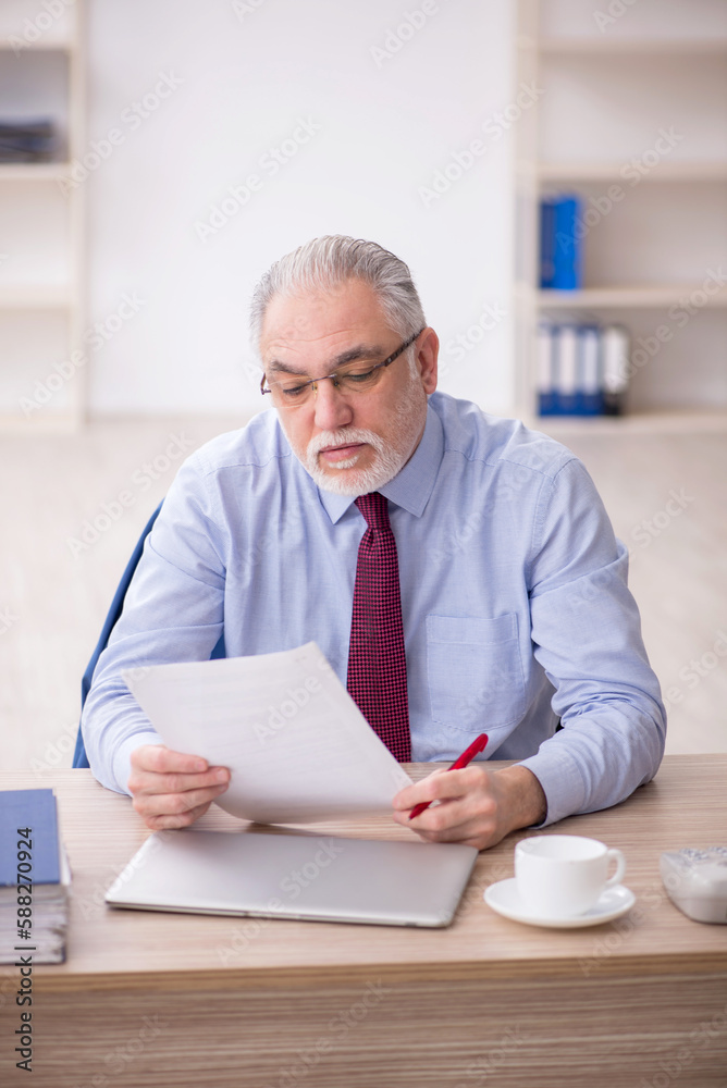 Old male employee and too much work at workplace Old male employee and too much work at workplace