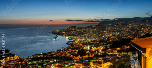 Panorama of Funchal, Madeira illuminated cityscape at sunset.