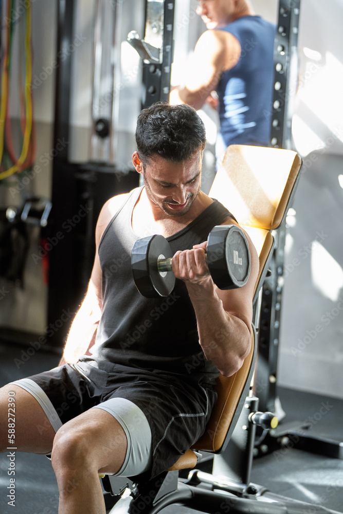 Fit young Caucasian man working out with weights at the gym Fit young Caucasian man working out with weights at the gym