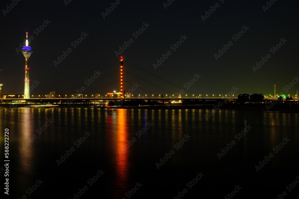 TV tower reflecting on Rhine River at night in Dusseldorf, Germany