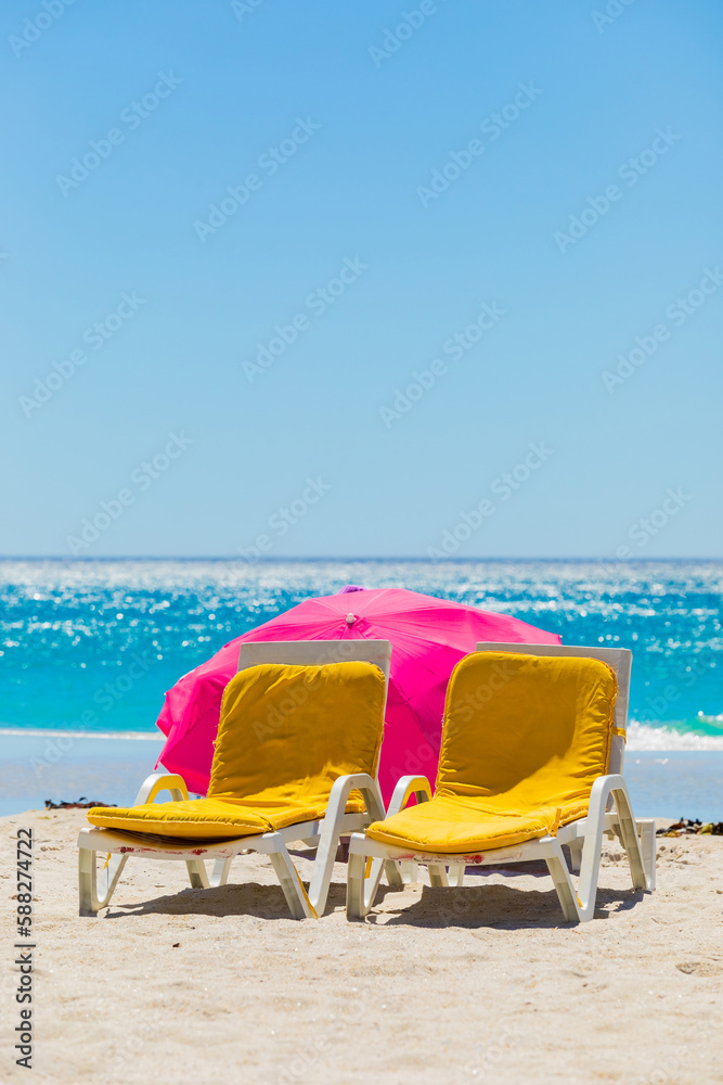 Lounger chairs and parasol umbrellas on sandy beach in Cape Town Lounger chairs and parasol umbrellas on sandy beach in Cape Town