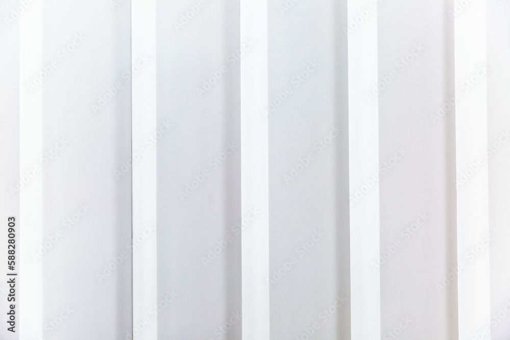 White slatted plastic wall panel. Modern trends in interior design. Space for text. White slatted plastic wall panel. Modern trends in interior design. Space for text.