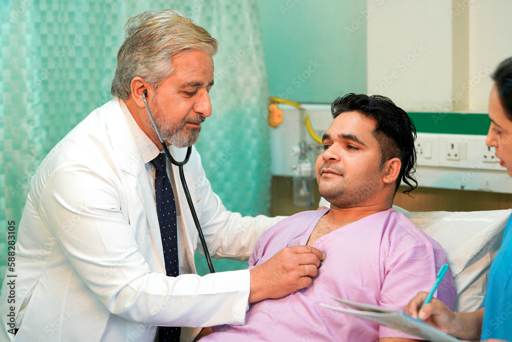 Senior Doctor check up using a stethoscope to patient on bed at hospital.