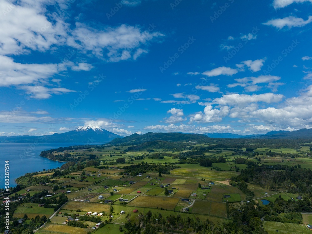Drone shot of the Osorno Volcano under the blue cloudy sky in Chile with Llanquihue lake on its foot
