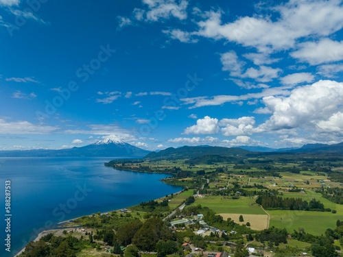 Drone shot of the Osorno Volcano under the blue cloudy sky in Chile with Llanquihue lake on its foot