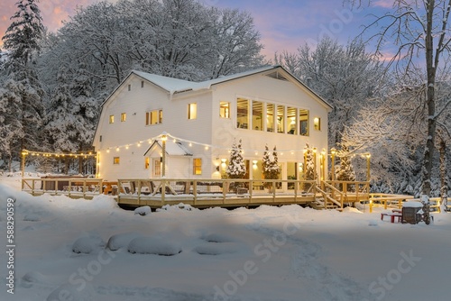 Beautiful white house surrounded by the trees on a snowy winter day