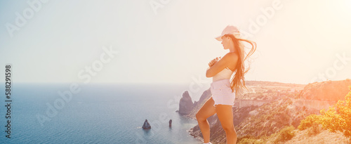 Woman summer travel sea. Happy tourist enjoy taking picture outdoors for memories. Woman traveler posing over sea bay surrounded by volcanic mountains, sharing travel adventure journey © panophotograph