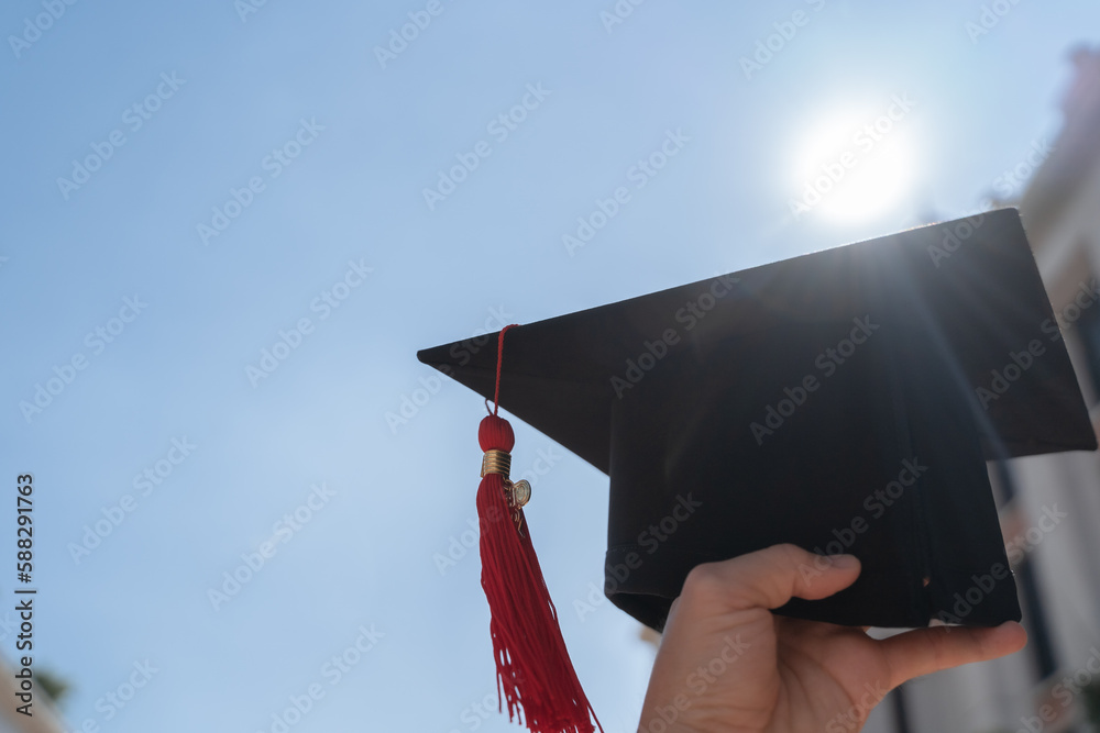 Graduation day concept, Graduation cap was holding on the air with blue