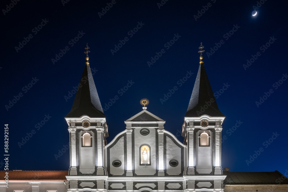 Obraz premium Tower of the white St. Paul church on the market square of Zilina at night, Slovakia