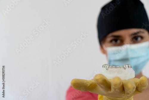 Female dentist showing lower jaw retainers