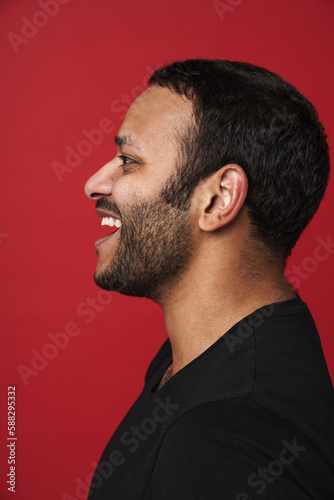 Profile of indian man smiling isolated over red studio background