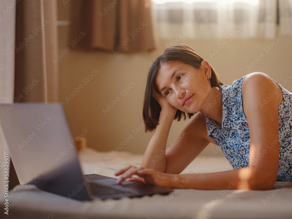 Happy young asian woman with laptop resting in bedroom in tiny house, weekend away and remote office idea. Tiny houses and Small Living concept. Happy young asian woman with laptop resting in bedroom in tiny house, weekend away and remote office idea. Tiny houses and Small Living concept.