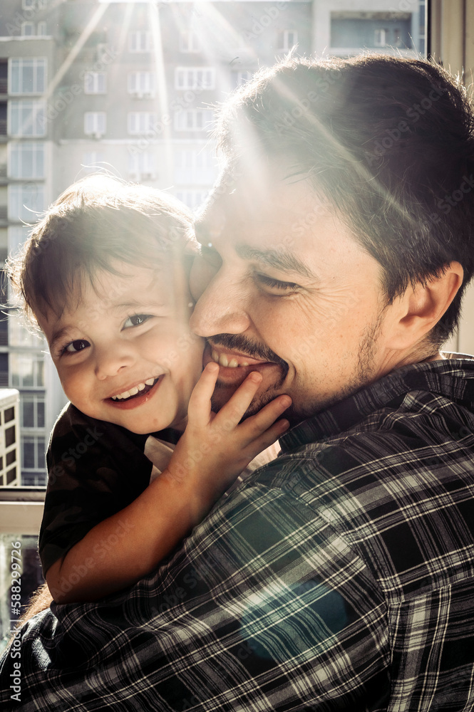 Happy boy enjoying with father on sunny day at home