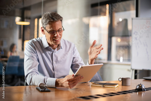 Portrait of businessman in office. Man using digital tablet. Businessman having video call