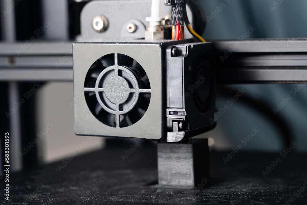 Fototapeta premium 3d printer closeup. Part of 3d printer called extruder. 3D printing technology background. Hotend of printer in work. Printing progress. Small object beeing printed out.