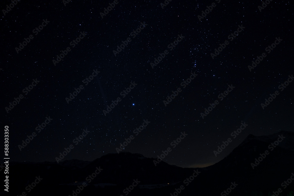 Idyllic shot of stars glowing over silhouette mountain and landscape at night