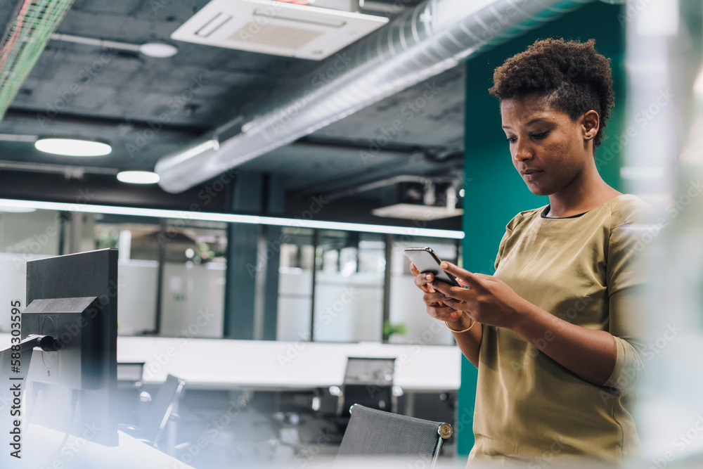 Businesswoman using smart phone in office Businesswoman using smart phone in office