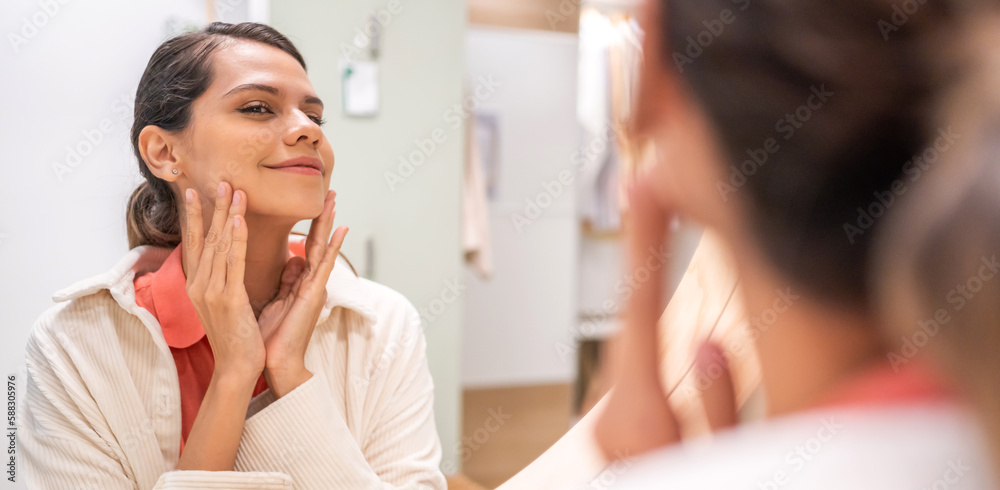Smiling of beautiful caucasian woman clean healthy white skin looking at mirror.beauty and fashion, hair, skin care, cosmetics, cosmetology, girl apply cream moisturizer on face.spa and wellness Smiling of beautiful caucasian woman clean healthy white skin looking at mirror.beauty and fashion, hair, skin care, cosmetics, cosmetology, girl apply cream moisturizer on face.spa and wellness