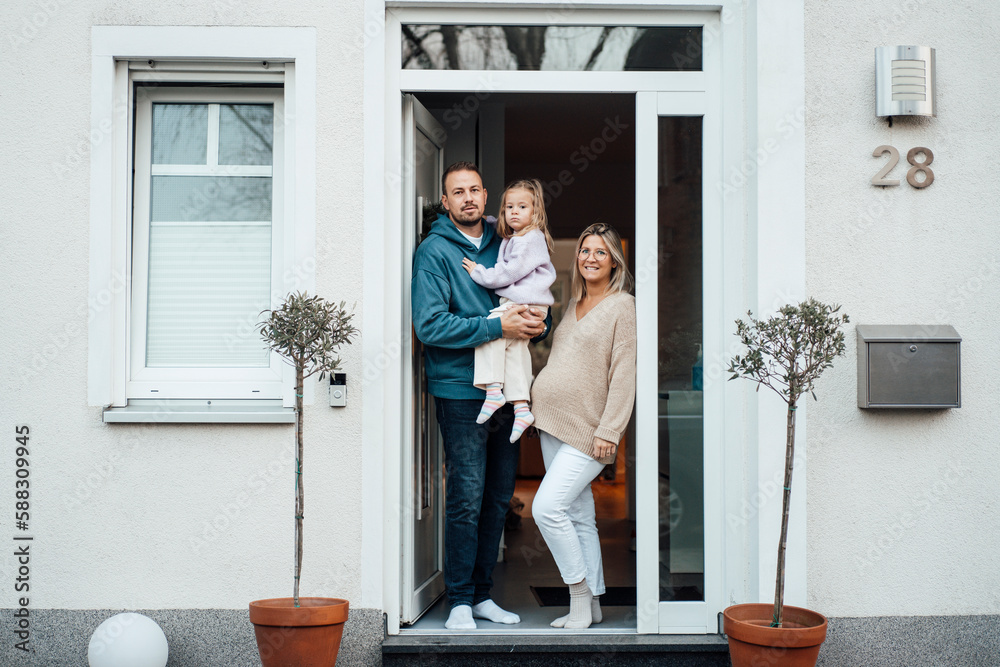 © Westend61 - Happy family standing at front door