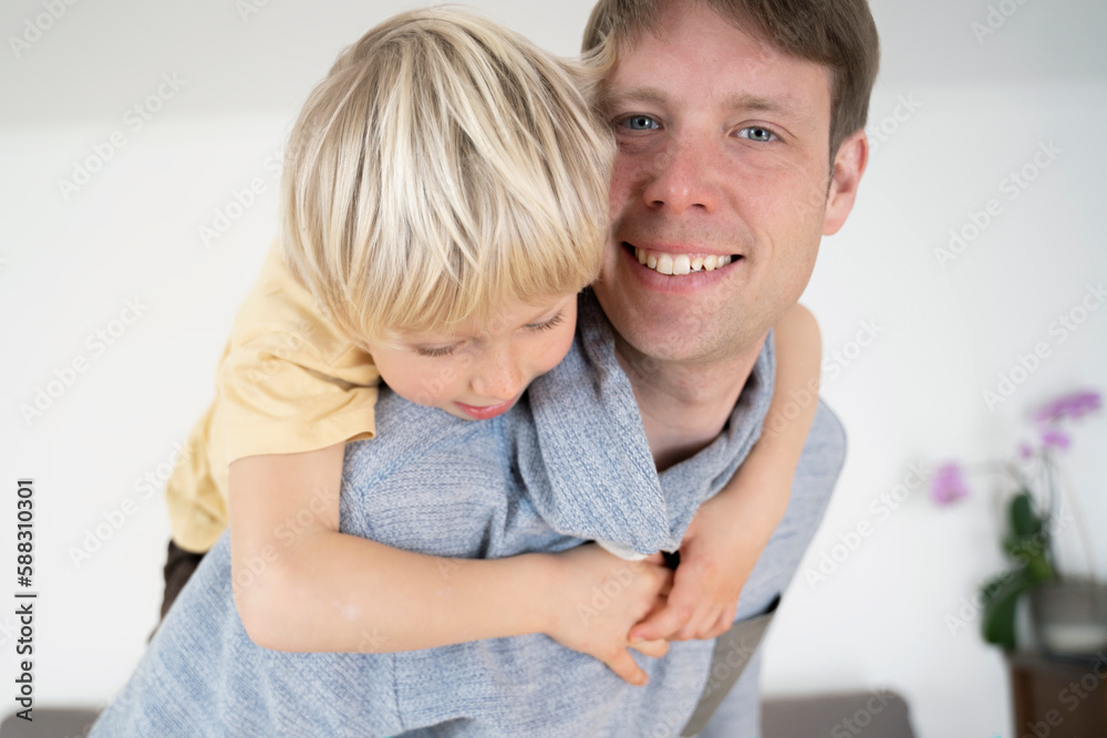 Happy father giving piggyback ride to son at home Happy father giving piggyback ride to son at home