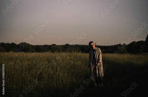 lonely man in a raincoat walks through the field, thinking about life. existential crisis