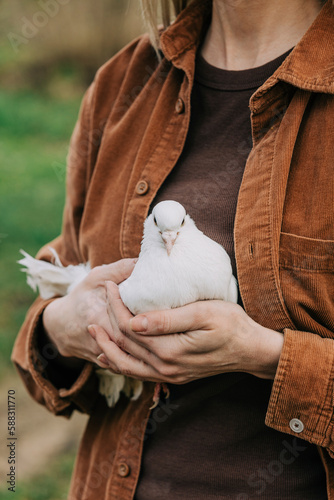 Farmer wearing brown shirt holding dove