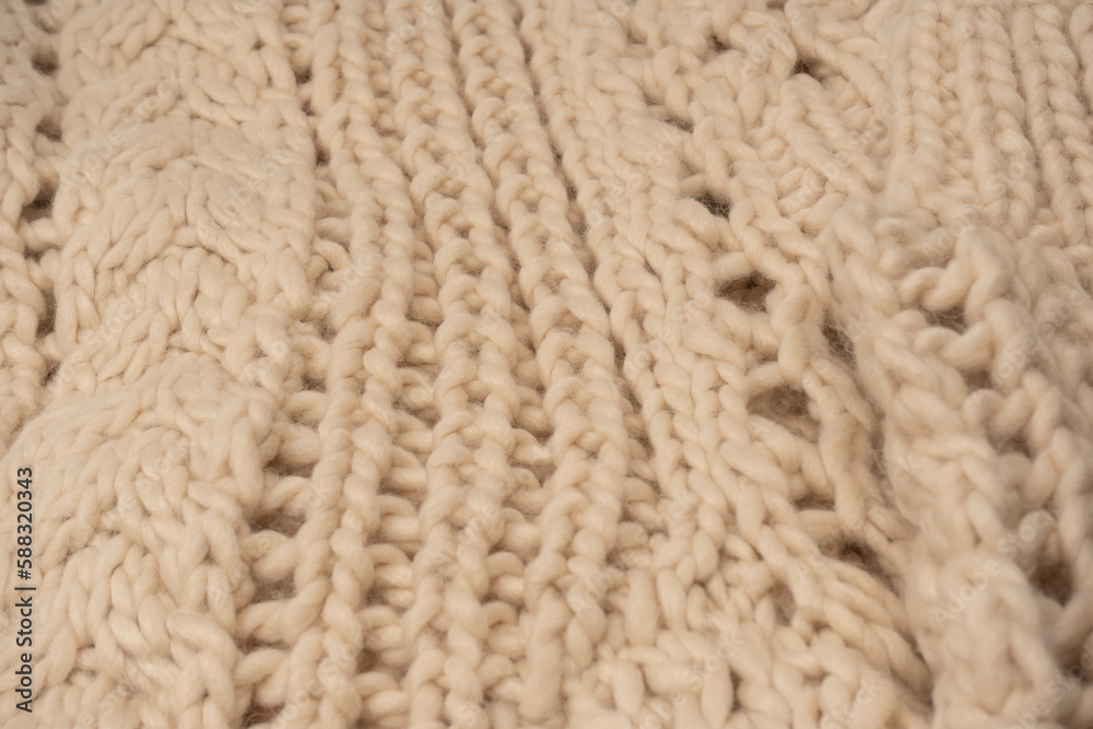 A fragment of beige knitted fabric, knitted from white sheep wool. A fragment of beige knitted fabric, knitted from white sheep wool.
