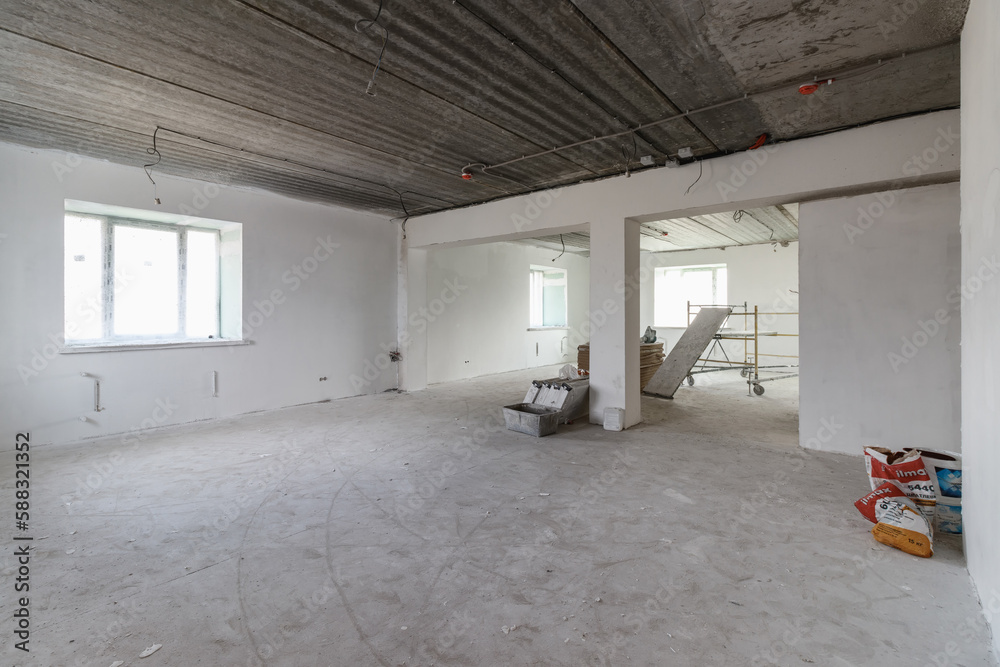Fototapeta premium Spacious empty rooms in the attic floor after filling out the work on the wall and ceiling