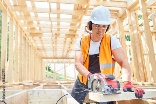 Craftsman, builder standing, looking down, cutting wodden gilder by professional equipment.