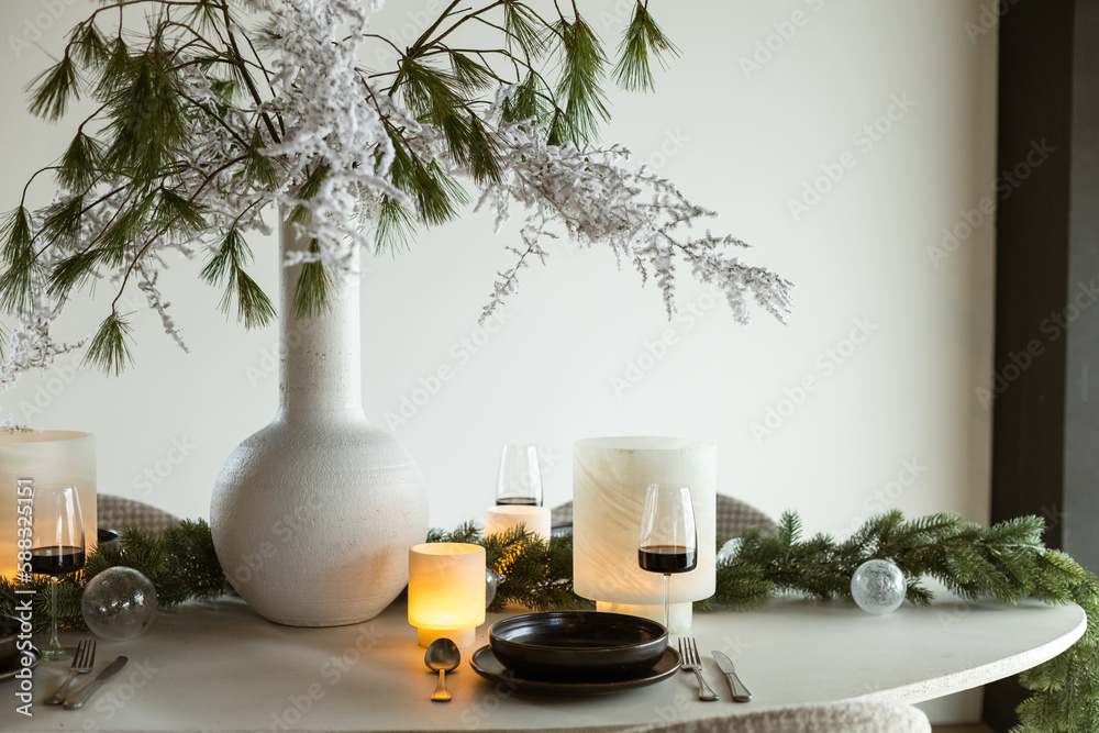 Complete Christmas dinner table decoration with candle lights and wine glasses Complete Christmas dinner table decoration with candle lights and wine glasses
