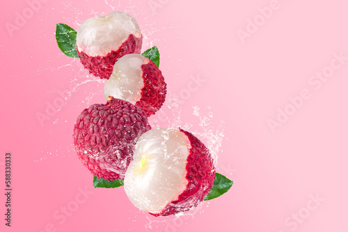 Creative layout made from Fresh lychee or litchi fruit and water splashing on a pastel pink background. Fruit minimal concept and copy space. photo