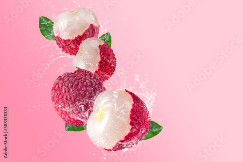 Obraz na płótnie Creative layout made from Fresh lychee or litchi fruit and water splashing on a pastel pink background. Fruit minimal concept and copy space. w salonie