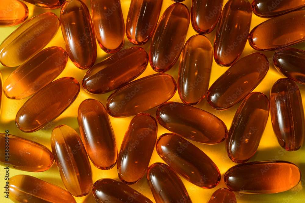 Omega 3 capsules on yellow bright background, close-up view of Omega 3 Omega 3 capsules on yellow bright background, close-up view of Omega 3