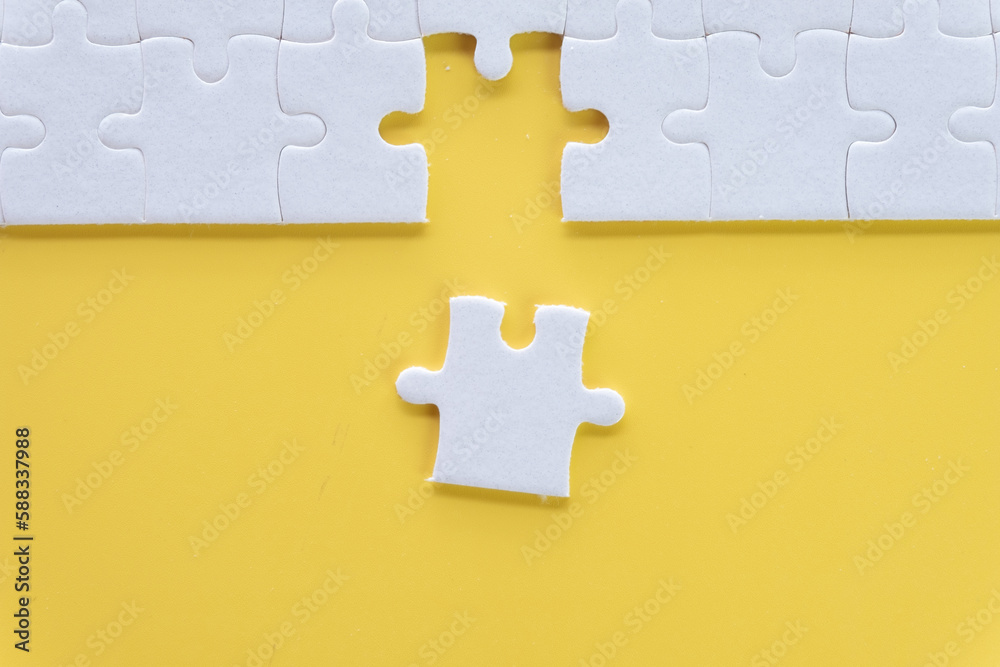 Obraz premium Top view photo of a White jigsaw or puzzle last piece to complete on yellow background with copyspace suitable for lat lay top view mock-up item,business and design,abstract concept.